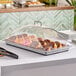 A black Cambro display tray holding donuts on a counter.