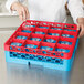 A person using a red Carlisle glass rack to hold glasses.