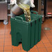 A person pouring liquid into a green container.