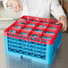 A person using a red Carlisle glass rack to hold glasses over a container of liquid.