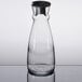 An Arcoroc clear glass carafe with a black stopper.