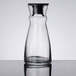 An Arcoroc clear glass carafe with a black stopper.