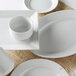A close up of a Tuxton Pacifica square white plate with an embossed rim.