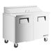 A white True Refrigerated Sandwich Prep Table with black handles on wheels.