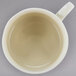 A white 10 Strawberry Street porcelain cup and saucer with a small amount of liquid in the cup.