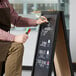 A black A-frame sign with a chalkboard on display on a table.