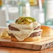 A close-up of a burger with white cheese sauce and vegetables.