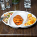 A Libbey porcelain divided platter with a chicken breast and side dish on it.