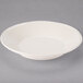 A Libbey Farmhouse ivory porcelain bowl with a rim on a gray surface.