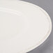 A close up of a Libbey Farmhouse ivory porcelain plate with a wide rim.