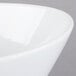 A close-up of a Libbey Ultra Bright White Neptune bowl with a curved rim.