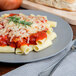 A plate of Regal rigatoni pasta with tomato sauce and cheese and a fork.