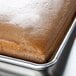 A brown cake baked in a MFG Tray full-size fiberglass pan with extender sides.