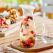 A Carlisle carafe filled with fruit and berries on a table.