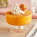 A dessert in a Choice Crystal clear plastic dessert cup with a pumpkin on top.