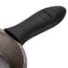 A Lodge black silicone handle holder on a black cast iron pan.