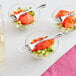 A Visions silver plastic tasting fork in a bowl of food.