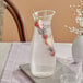 A Carlisle clear plastic carafe with a drink and fruit in it on a table.