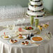 A table with Visions 2-piece martini cups filled with food, a bowl of salad with strawberries and pecans, and a glass of wine.