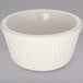 A white Carlisle fluted ramekin on a gray surface.