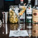 a martini glass with olives on a table