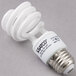 A white Satco mini spiral compact fluorescent light bulb.