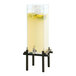 A Cal-Mil black plastic beverage dispenser with lemons and yellow liquid inside.