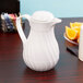 A Vollrath SwirlServe white hot and cold beverage server on a table.