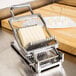 A piece of cheese being sliced in a Nemco Easy Cheeser.