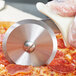 A person using a Dexter-Russell pizza cutter to slice a pizza.