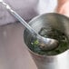 A Tablecraft bar mixing spoon in a metal cup of ice.