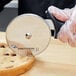 A person cutting a cookie with a Dexter-Russell pizza cutter.