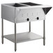 A stainless steel ServIt electric steam table with an undershelf holding two square containers.