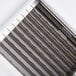A close up of a metal pusher head and blade assembly with black and white stripes.