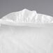 A white rectangular plastic tablecloth with elastic edges.