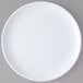 A Carlisle white melamine plate with a white rim on a gray surface.