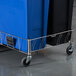 A blue plastic bin on a Rubbermaid Slim Jim stainless steel dolly.