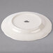 A Tuxton ivory china plate with a scalloped edge.
