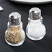 Two American Metalcraft glass lightbulb salt and pepper shakers on a table.