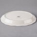 A white Tuxton oval china platter with a scalloped edge.