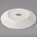 A Tuxton ivory china plate with a black scalloped edge.