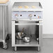 A Cooking Performance Group natural gas griddle on a counter with pans and bowls inside.