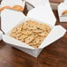 A table with a white Fold-Pak Bio-Pak take-out box full of cookies.