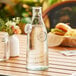 A Tablecraft green tint glass carafe with water on a table.