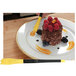 A plate of food with a Mercer Culinary saw tooth silicone brush, a yellow fork, and a knife.