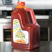 A plastic jug of Kikkoman Sweet and Sour Sauce on a counter.