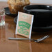 A Bromley Organic Green Tea bag in a black bowl with a spoon.