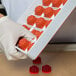 A gloved hand holding a tray of red Martellato fruit jelly molds.