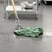 A Rubbermaid green blend wet mop head on the floor.