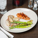 An ivory oval platter with food on a table.